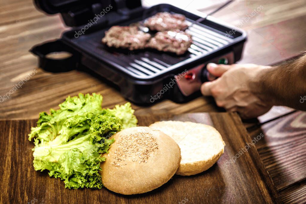 Cucinare hamburger domestici utilizzando griglia elettrica su un