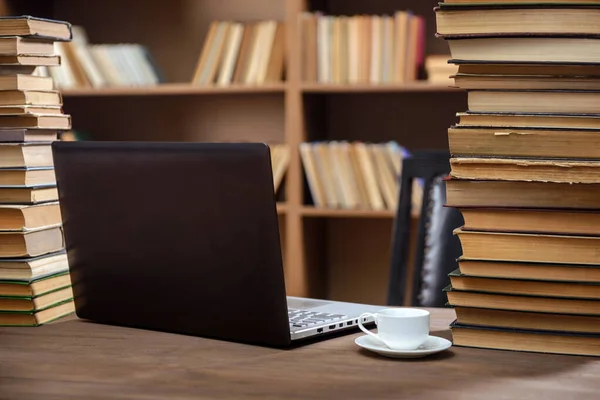 Espacio de trabajo para trabajar y estudiar con un portátil y una taza de café en la mesa de la biblioteca — Foto de Stock