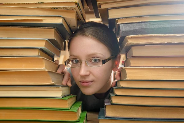 Дівчина в окулярах шукає старі книги в бібліотеці — стокове фото