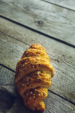 Eski ahşap masa üzerinde çıtır tereyağı kruvasan