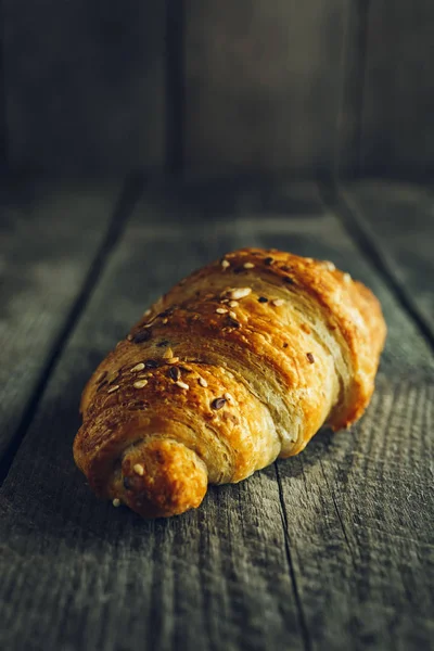 Crispy buttery croissants on old wooden table — Stock Photo, Image