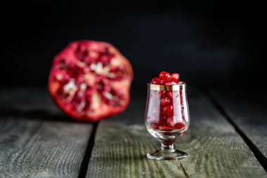 Olgun nar taneleri vintage ahşap arka plan üzerinde küçücük bir cam