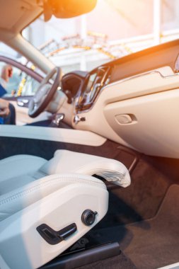 Yeni modern bir arabanın içi beyaz deri, pencereden içeri akşam güneşi giriyor..