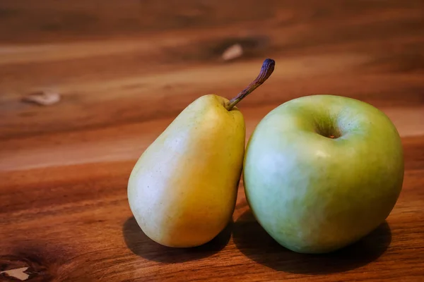 Свежая груша и яблоко на деревянном столе — стоковое фото