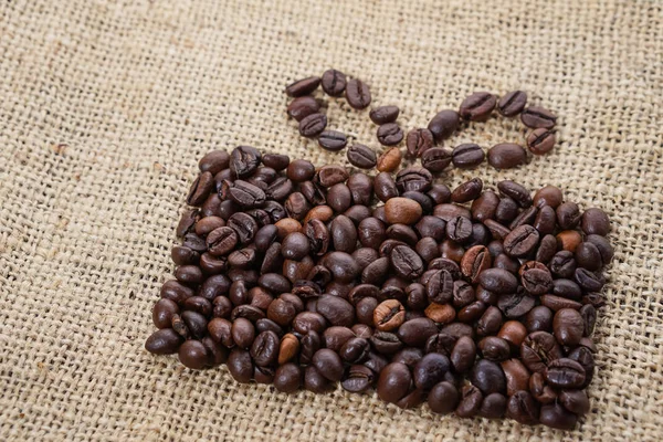 Regalo hecho de granos de café sobre tela de saco — Foto de Stock