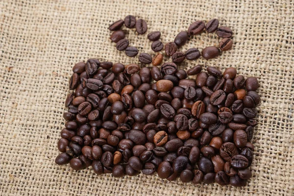 Regalo hecho de granos de café sobre tela de saco — Foto de Stock