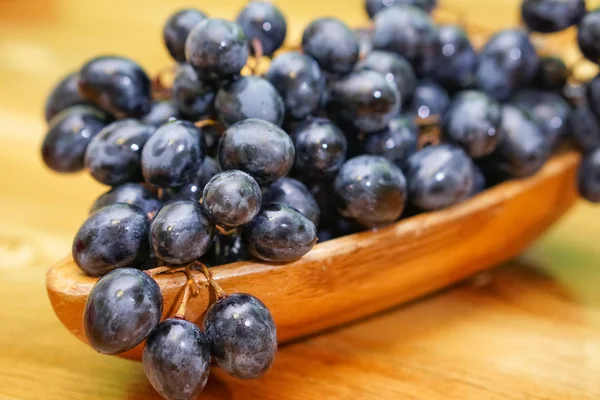 Świeże winogrona w drewniane miski na drewnianym stole — Zdjęcie stockowe