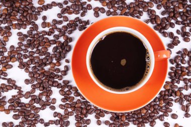 Kahve turuncu fincan kahve çekirdekleri ile çevrili