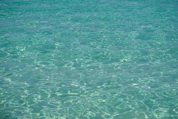 Transparentní tirquoise mořskou vodou s malým vlny — Stock fotografie