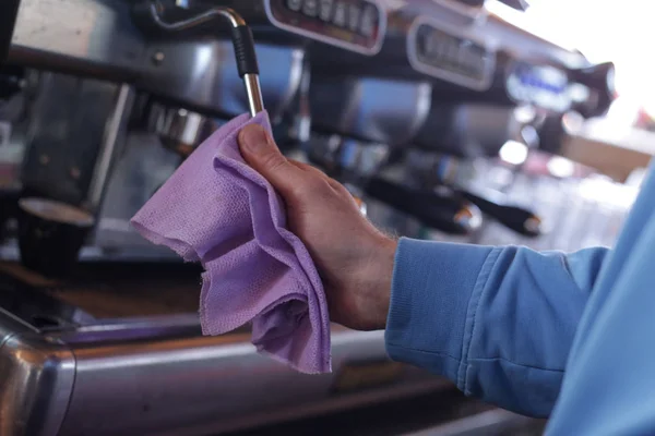 Mann reinigt Kaffeemaschine mit lila Putztuch — Stockfoto