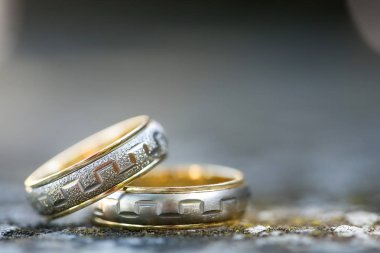 Bulanık arkaplanı olan betonun üzerindeki iki alyansı kapat