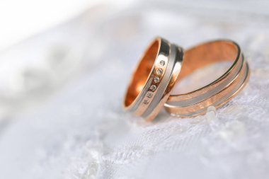 Beyaz tekstil üzerine iki bronz alyans.