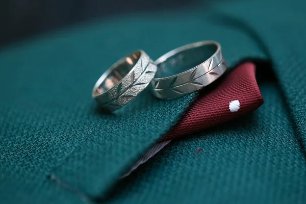 Deux anneaux sur costume de mariage vert masculin. Macro gros plan des alliances — Photo