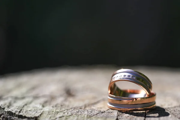 Macro primer plano de dos anillos de boda en madera —  Fotos de Stock