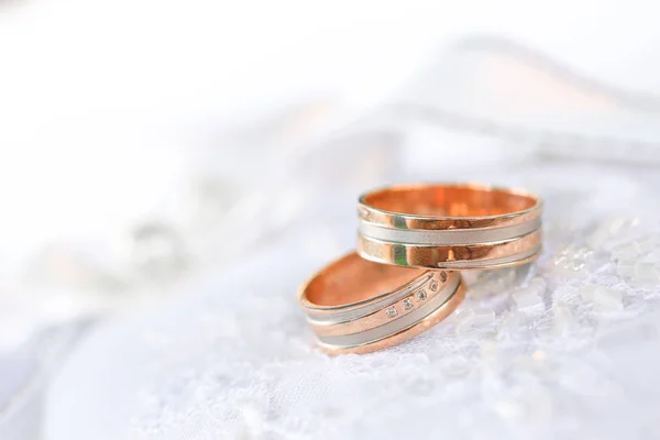 Dos anillos de boda de bronce en textil blanco —  Fotos de Stock