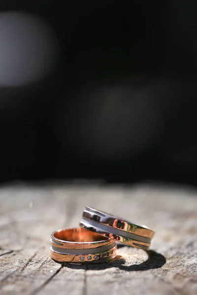 Macro primer plano de dos anillos de boda en madera —  Fotos de Stock