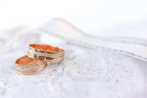 Dos anillos de boda de bronce en textil blanco —  Fotos de Stock
