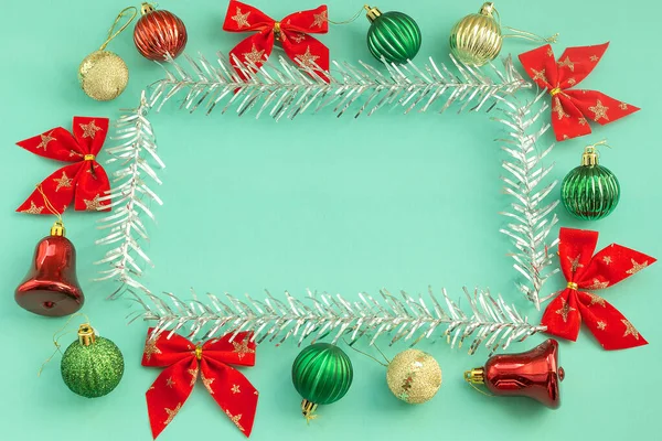 Composição de Natal de brinquedos bolas arcos sinos decorações sobre papel de hortelã fundo com espaço de cópia armação de árvore de prata . — Fotografia de Stock