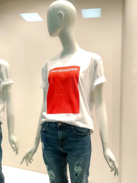 Maniquí con camisetas blancas con texto rojo Venta en escaparate tienda de ropa . — Foto de Stock