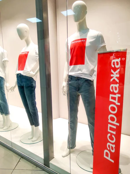 Maniquíes con camisetas blancas con texto rojo Venta en escaparate tienda de ropa . — Foto de Stock