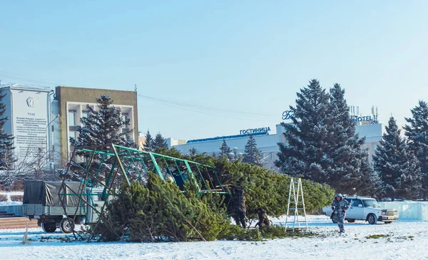 Ulan-Ude, Rusia, 12.04.2019: Arreglo festivo de la plaza principal de la ciudad en Año Nuevo. Los trabajadores instalan un árbol de Navidad . — Foto de Stock