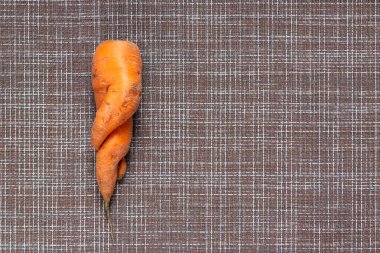 Beyaz kağıtta deforme olmuş çirkin havuç, çirkin organik gıda, sıfır atık kavramı ve kopyalama alanı.