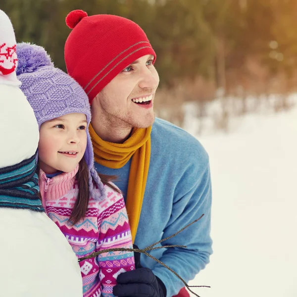 Pai e filha com boneco de neve — Fotografia de Stock