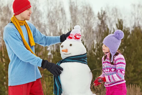 Vater und Tochter mit Schneemann — Stockfoto