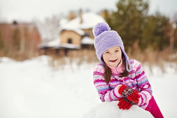 Niño construyendo un muñeco de nieve — Foto de Stock