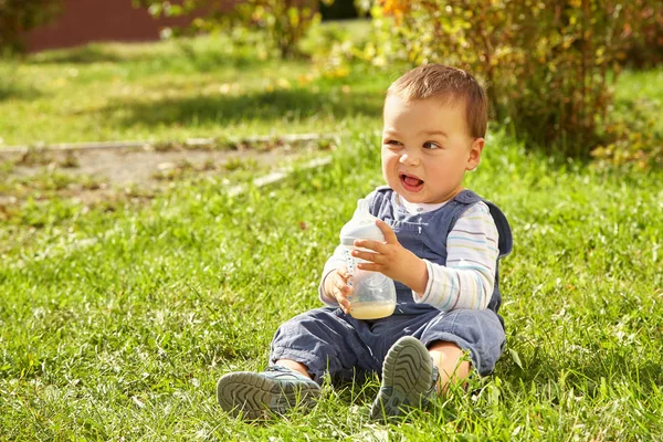 Niño sentado en la hierba —  Fotos de Stock