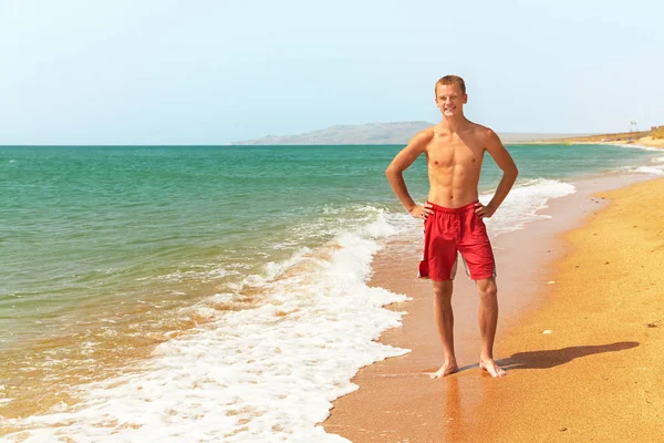 Atlético homem na praia — Fotografia de Stock