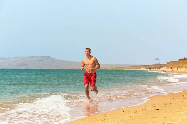 Mężczyzna biegający po plaży. — Zdjęcie stockowe
