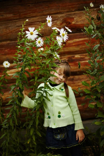 Kleines Mädchen im Garten mit Blumen — Stockfoto
