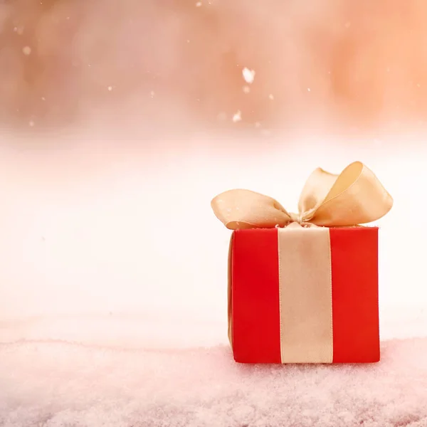 Červená zima vánoční dárek box ve sněhu pozadí venku. — Stock fotografie