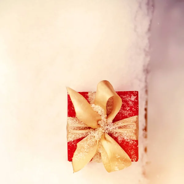 Červená zima vánoční dárek box ve sněhu pozadí venku. — Stock fotografie