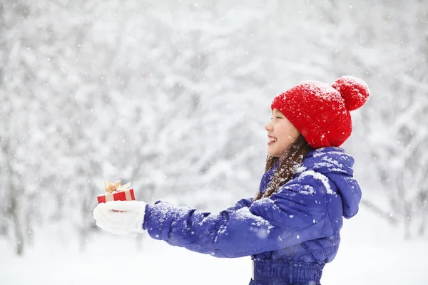 Teenage girl with a gift in her hands. adolescent winter outdoors — Stock Photo, Image