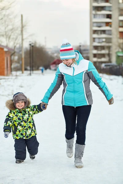 Happy mother and baby walking in winter. family outdoors. cheerful mom with her child. — Stock Photo, Image