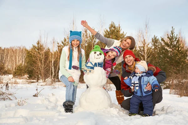 Portret rodziny wesoły bałwana. szczęśliwe dzieci i rodziców w zimie na zewnątrz. — Zdjęcie stockowe