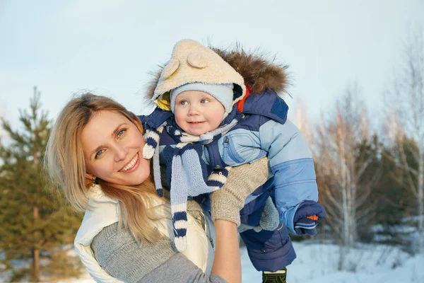 Happy mother and baby in winter park. family outdoors. cheerful mommy with her child. — Stock Photo, Image