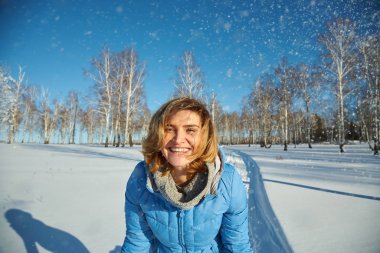 Kışın yürüyüşe çıkan mutlu bir kadın. Kız dışarıda karın tadını çıkarıyor..