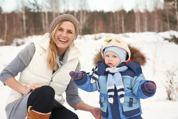 Šťastná matka a dítě v zimě parku. rodina venku. Veselá maminka s dítětem. — Stock fotografie