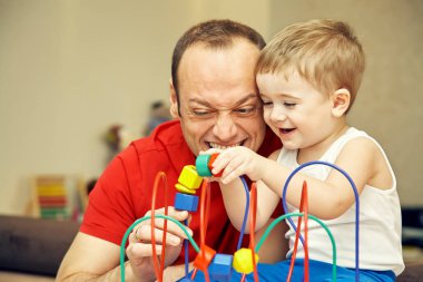 Baba, evdeki oyun geliştirmede çocuğuyla oynuyor. Baba ve oğul eğleniyor..