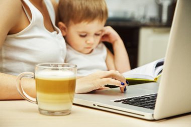 Çocuklu anne bilgisayarda çalışıyor.