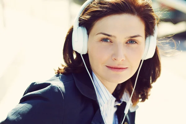 Retrato al aire libre de una mujer elegante con auriculares en una calle . — Foto de Stock