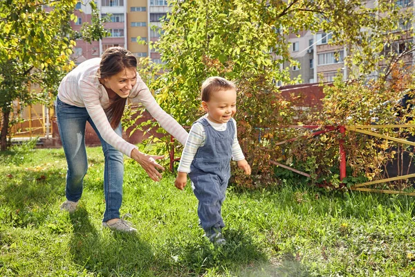 Junge Mutter spielt mit ihrem Baby. Mutter und Sohn spazieren im Park. — Stockfoto