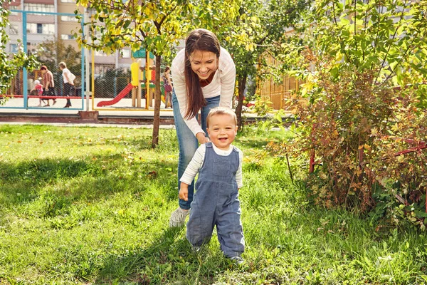 แม่สาวเล่นกับลูกของเธอ แม่กับลูกเดินในสวนสาธารณะ . — ภาพถ่ายสต็อก