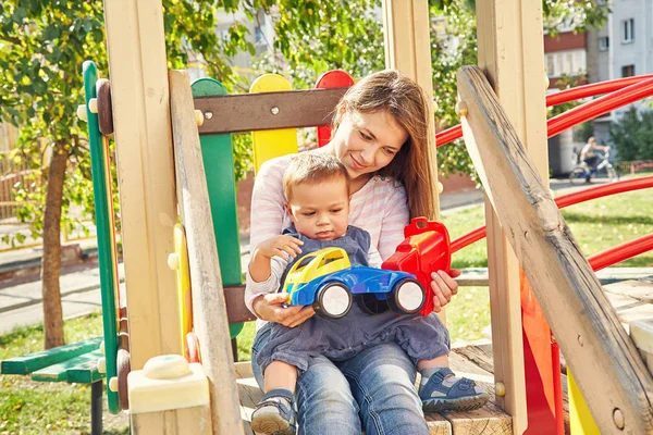 Ung mor med sitt barn på lekplatsen — Stockfoto