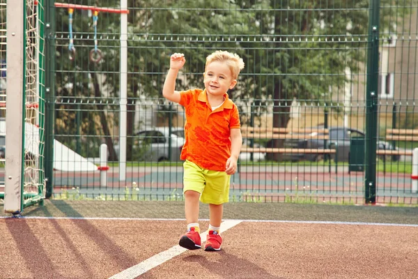 フットボールのゲートのグリッドが遊び場で面白い男の子。運動場で遊ぶ子供. — ストック写真