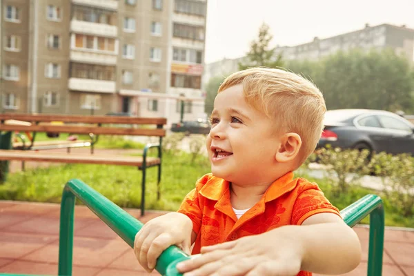 Un niño activo en el patio de recreo. jugando niño en alegre dar la vuelta . —  Fotos de Stock
