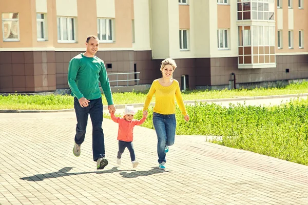 Lycklig spela familj utomhus. unga föräldrar med en baby för en promenad på sommaren. Mamma, Pappa och barn. — Stockfoto